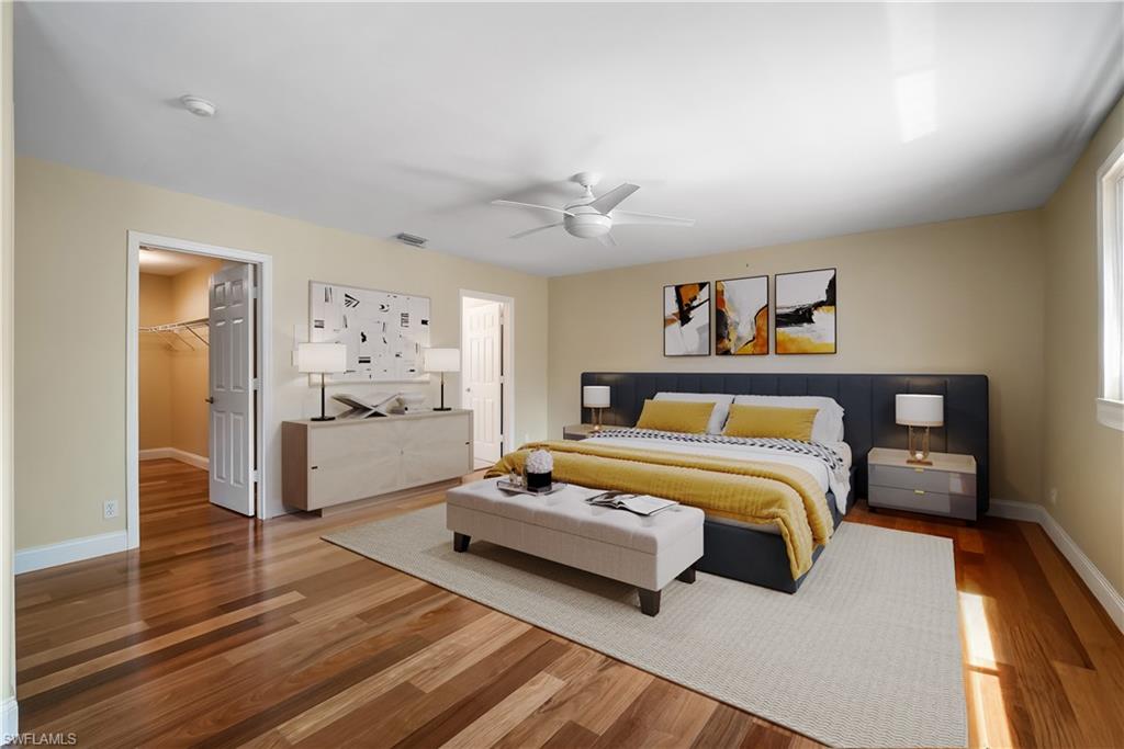 5801 Lago Villaggio Way Naples, FL 34104 - Photo 6 of 23 Bedroom featuring a walk in closet, wood finished floors, and a ceiling fan