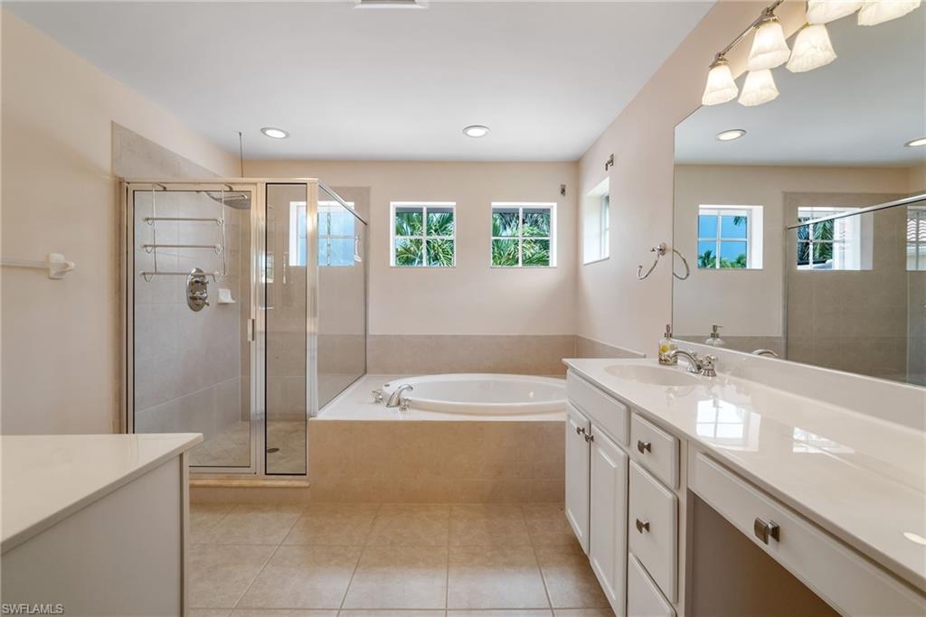 5801 Lago Villaggio Way Naples, FL 34104 - Photo 9 of 23 Full bathroom with vanity, a garden tub, a stall shower, plenty of natural light, and recessed lighting