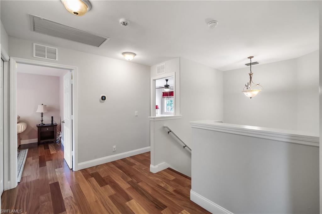 5801 Lago Villaggio Way Naples, FL 34104 - Photo 10 of 23 Corridor featuring an upstairs landing and dark wood finished floors