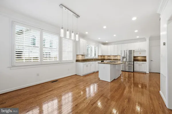 a kitchen with kitchen island white cabinets and stainless steel appliances