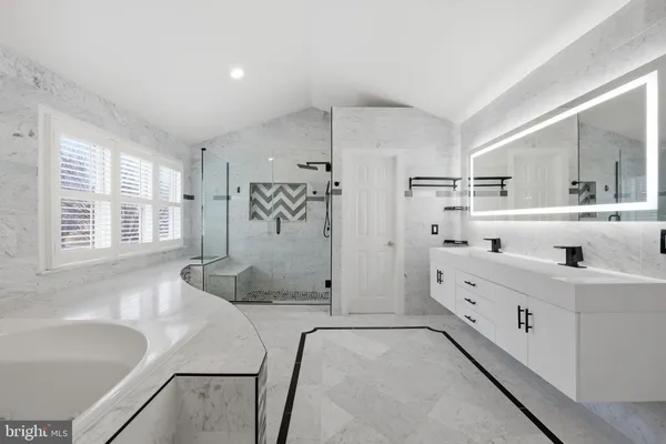 a bathroom with a tub sink and mirror