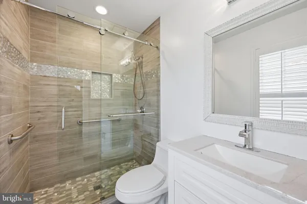 a bathroom with a sink a toilet and shower