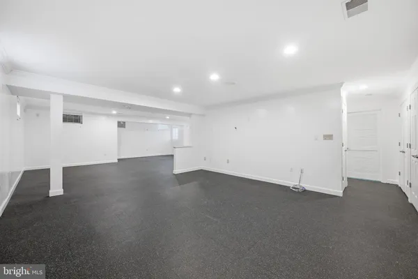 an empty room with staircase and white walls