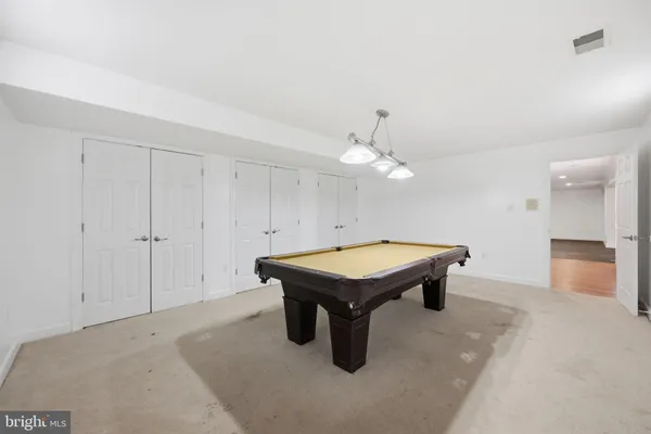 a room with pool table and ceiling fan