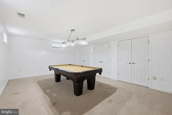 a room with pool table and ceiling fan