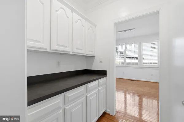 a kitchen with granite countertop white cabinets and a window