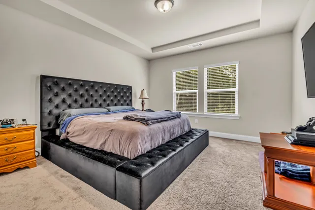 a bed sitting in a bedroom next to a window