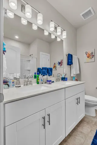 a bathroom with a sink a large mirror and vanity