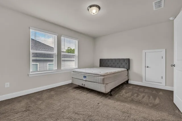 a spacious bedroom with a bed and a window