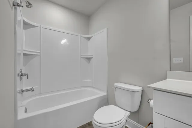 a white toilet and tub sitting next to a bathroom sink