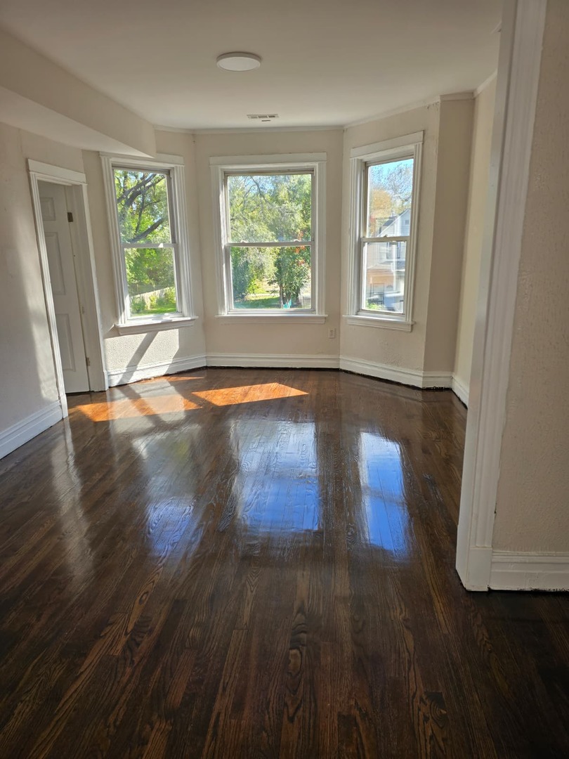 5740 South Elizabeth Street Chicago, IL 60636 - Photo 13 of 45 a view of an empty room with wooden floor and window