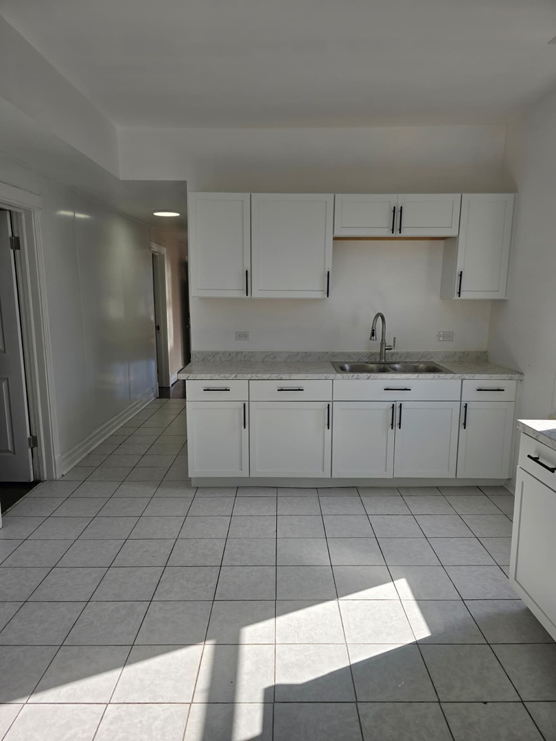 5740 South Elizabeth Street Chicago, IL 60636 - Photo 14 of 45 a kitchen with a sink a stove and cabinets