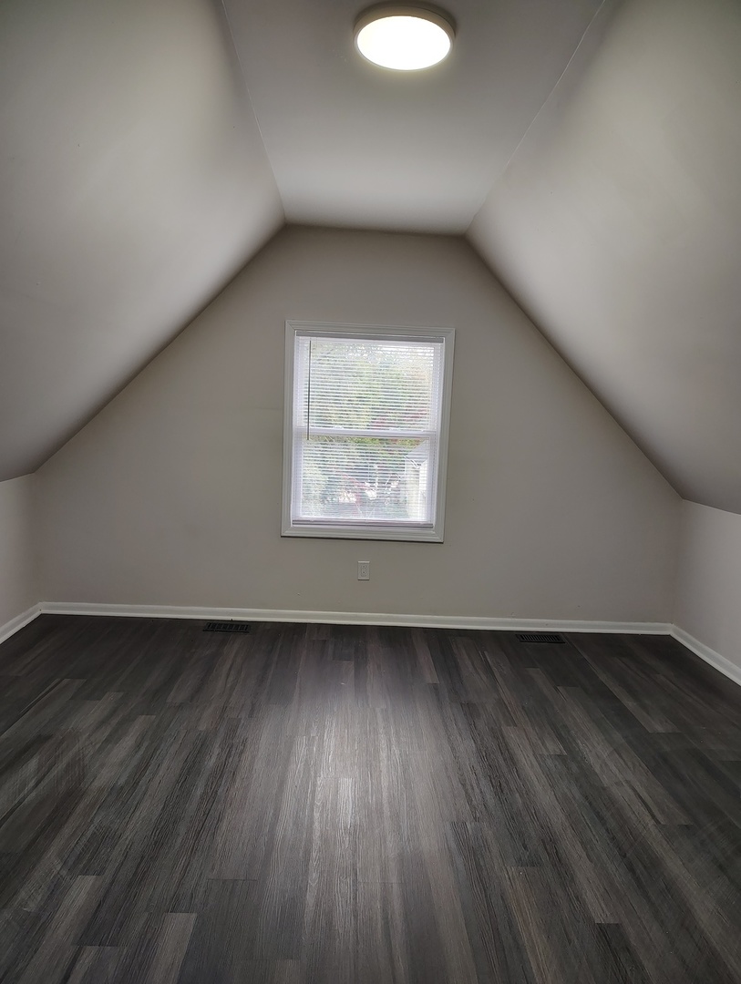 5740 South Elizabeth Street Chicago, IL 60636 - Photo 19 of 45 an empty room with wooden floor and windows