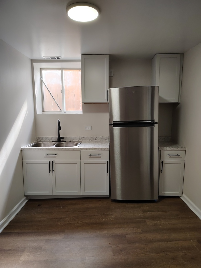 5740 South Elizabeth Street Chicago, IL 60636 - Photo 33 of 45 a kitchen with a refrigerator sink stove and cabinets