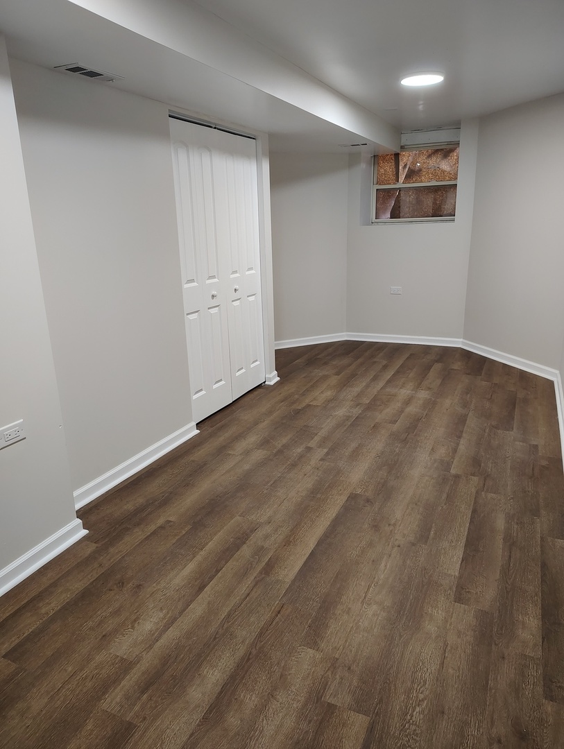 5740 South Elizabeth Street Chicago, IL 60636 - Photo 34 of 45 an empty room with wooden floor and windows