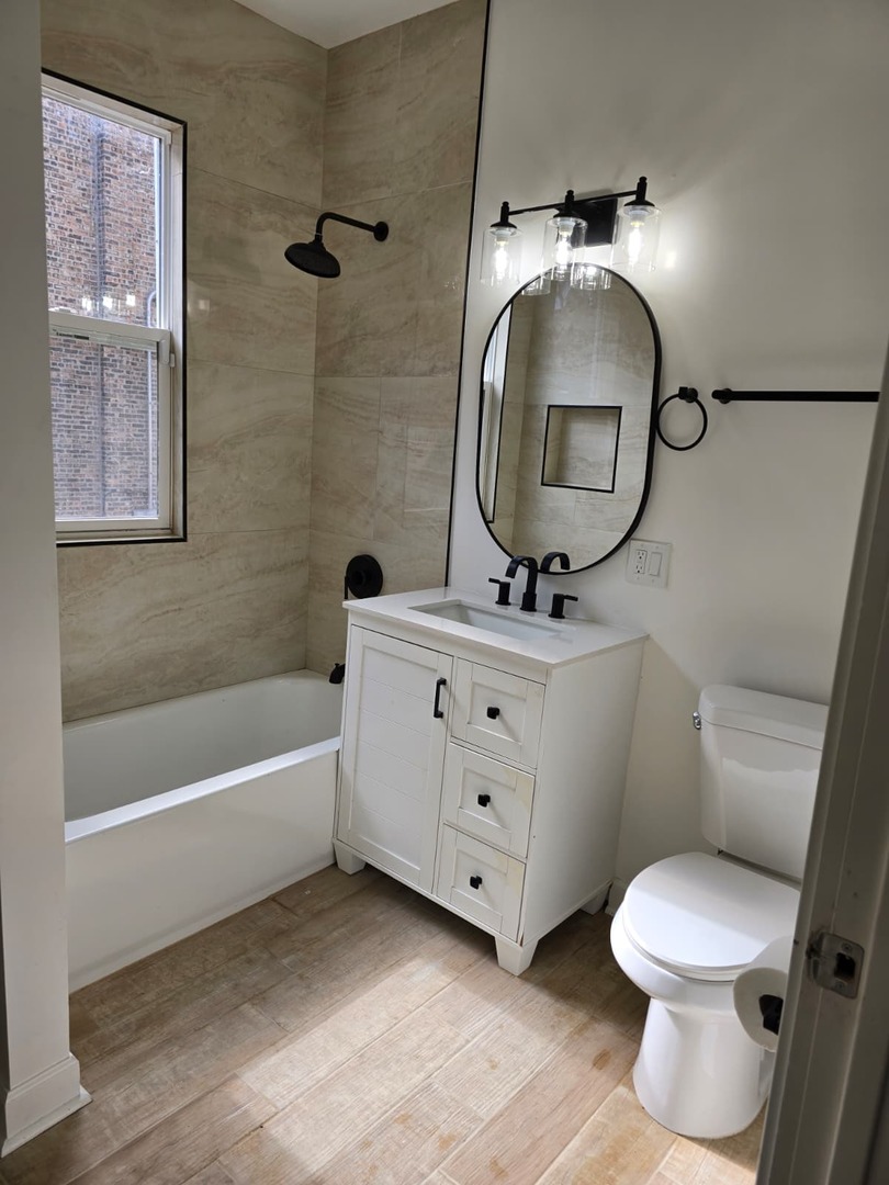 5740 South Elizabeth Street Chicago, IL 60636 - Photo 37 of 45 a bathroom with a toilet a sink and mirror