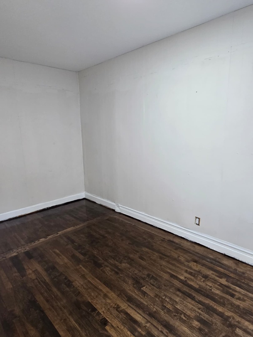 5740 South Elizabeth Street Chicago, IL 60636 - Photo 9 of 45 a view of an empty room with wooden floor