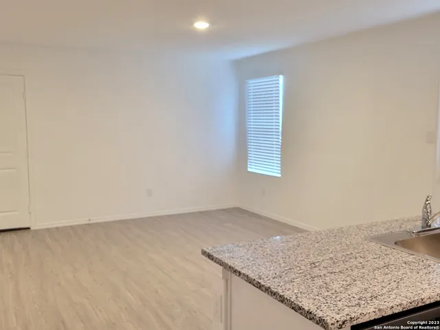 a view of an empty room and kitchen stove