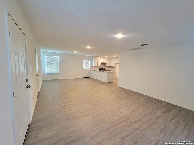 a view of a big room with wooden floor and windows