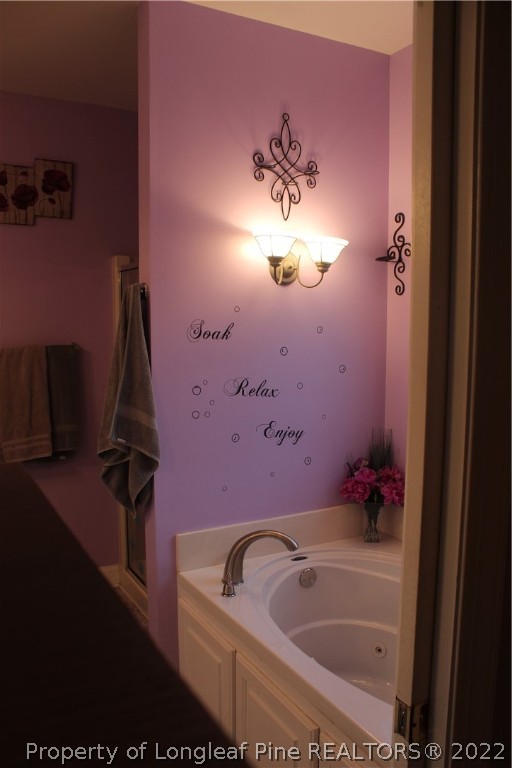 678 Tilghman Road Coats, NC 27521 - Photo 20 of 47 a bathroom with a tub sink and mirror