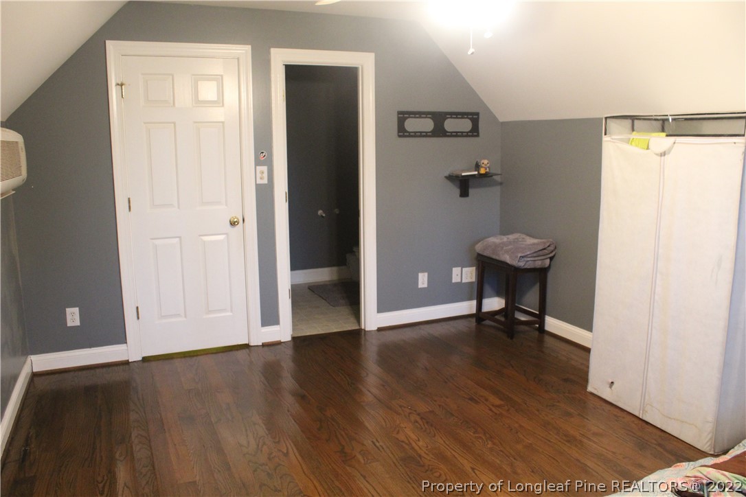 678 Tilghman Road Coats, NC 27521 - Photo 35 of 47 a view of an empty room with wooden floor and a bathroom