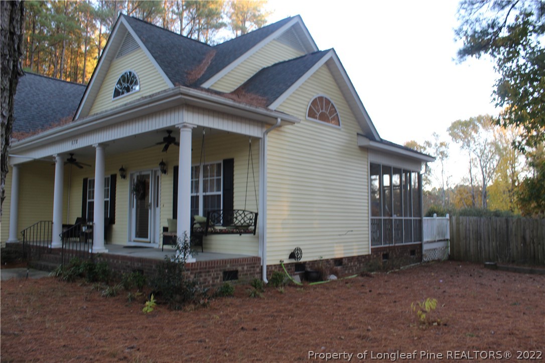 678 Tilghman Road Coats, NC 27521 - Photo 4 of 47 a view of a white house with large windows and a small yard