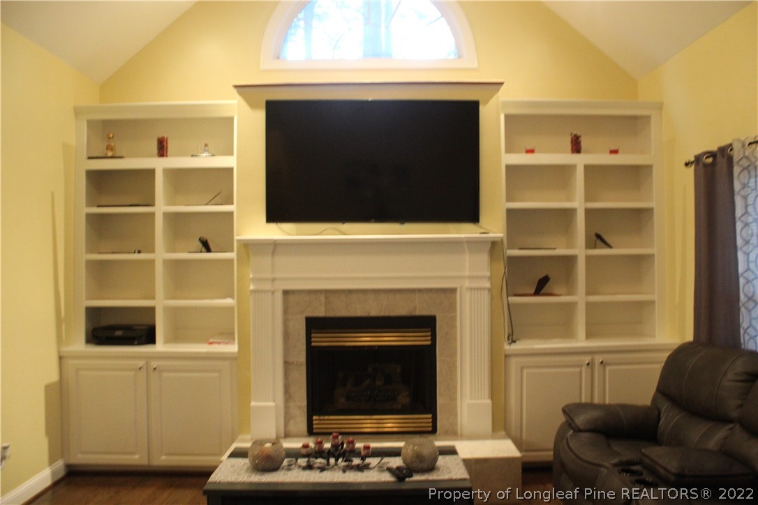 678 Tilghman Road Coats, NC 27521 - Photo 41 of 47 a living room with a fireplace and a flat screen tv