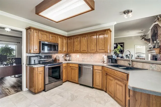 a kitchen with stainless steel appliances granite countertop a sink dishwasher stove top oven and refrigerator with wooden floor