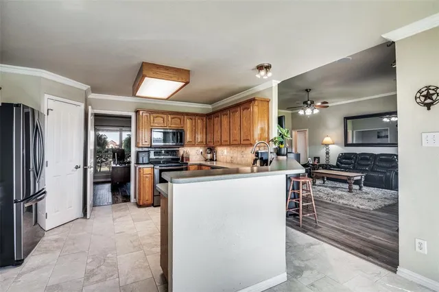 a kitchen with stainless steel appliances kitchen island granite countertop a refrigerator and a stove top oven