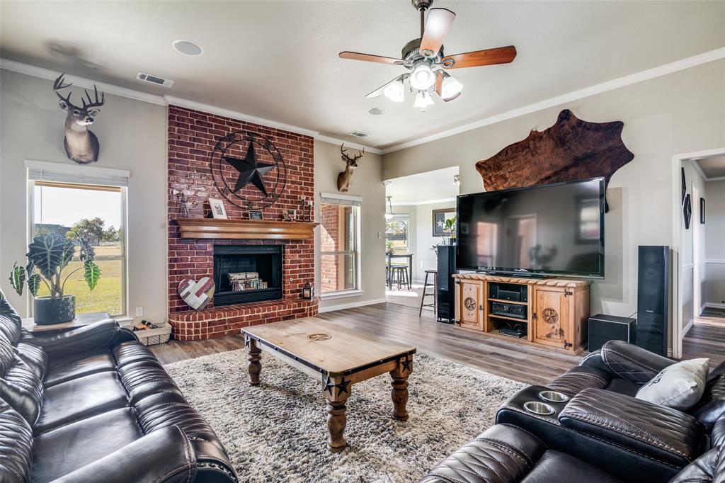 13064 Highland Court Forney, TX 75126 - Photo 8 of 25 a living room with furniture a flat screen tv and a fireplace