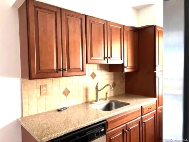 a kitchen with granite countertop white cabinets and sink