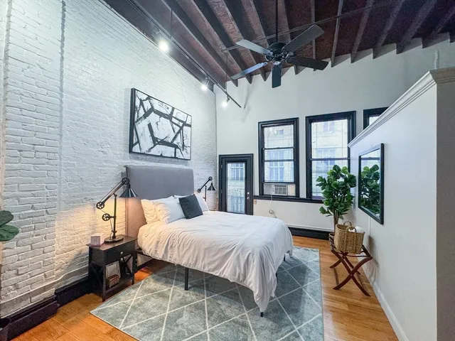 a bedroom with a bed and wooden floor