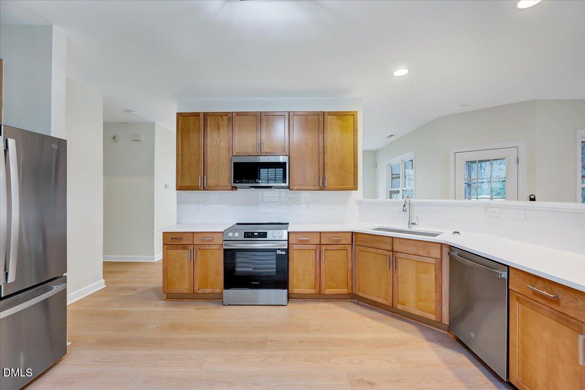 3218 Trassacks Drive Raleigh, NC 27610 - Photo 13 of 37 a large kitchen with stainless steel appliances granite countertop a sink stove and refrigerator