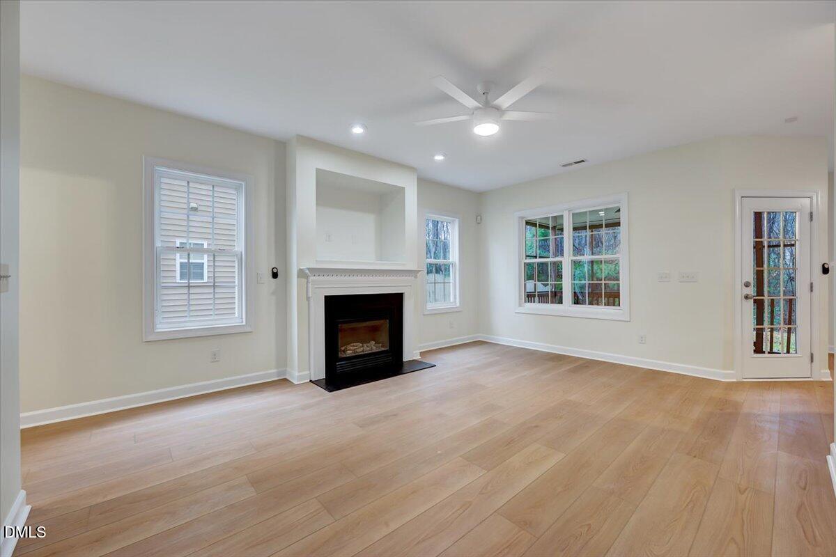 3218 Trassacks Drive Raleigh, NC 27610 - Photo 7 of 37 a view of an empty room with a fireplace and a window