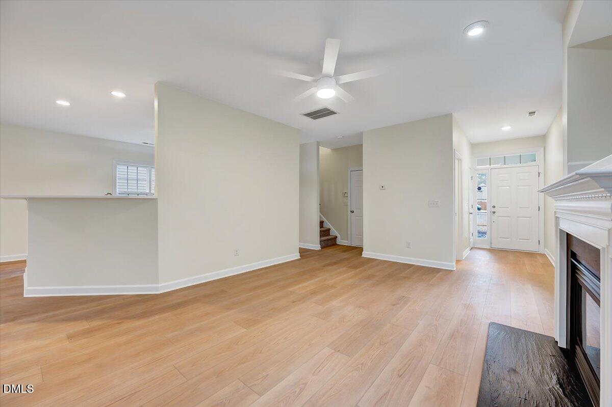 3218 Trassacks Drive Raleigh, NC 27610 - Photo 9 of 37 a view of empty room with wooden floor and fireplace