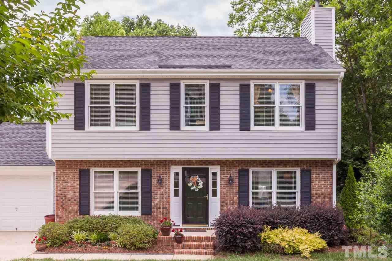 7317 Ridge Grove Court Raleigh, NC 27615 - Photo 1 of 25 a view of a brick house with a large windows and a yard