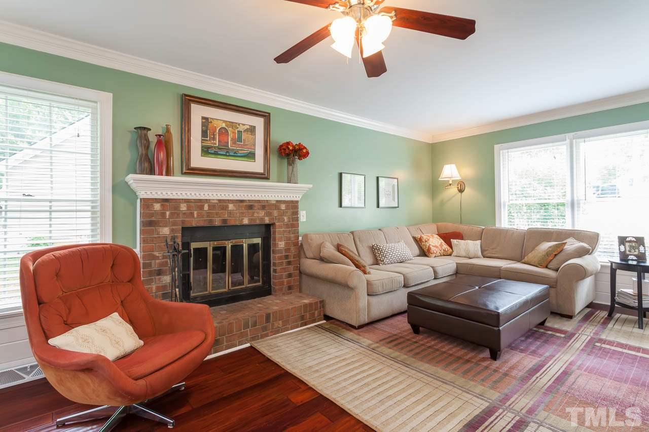 7317 Ridge Grove Court Raleigh, NC 27615 - Photo 18 of 25 a living room with furniture a large window and a fireplace