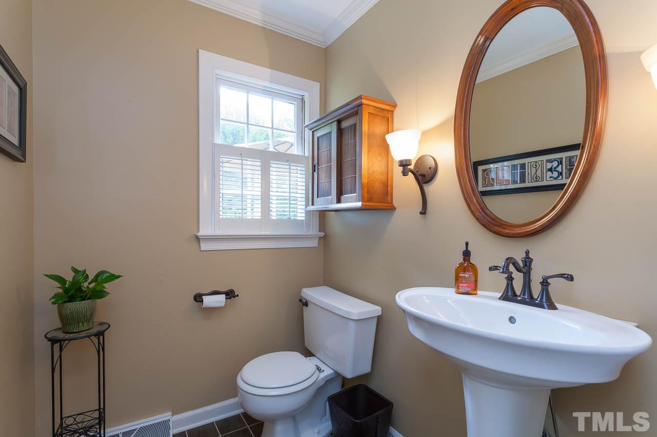 7317 Ridge Grove Court Raleigh, NC 27615 - Photo 22 of 25 a bathroom with a toilet a sink and a mirror