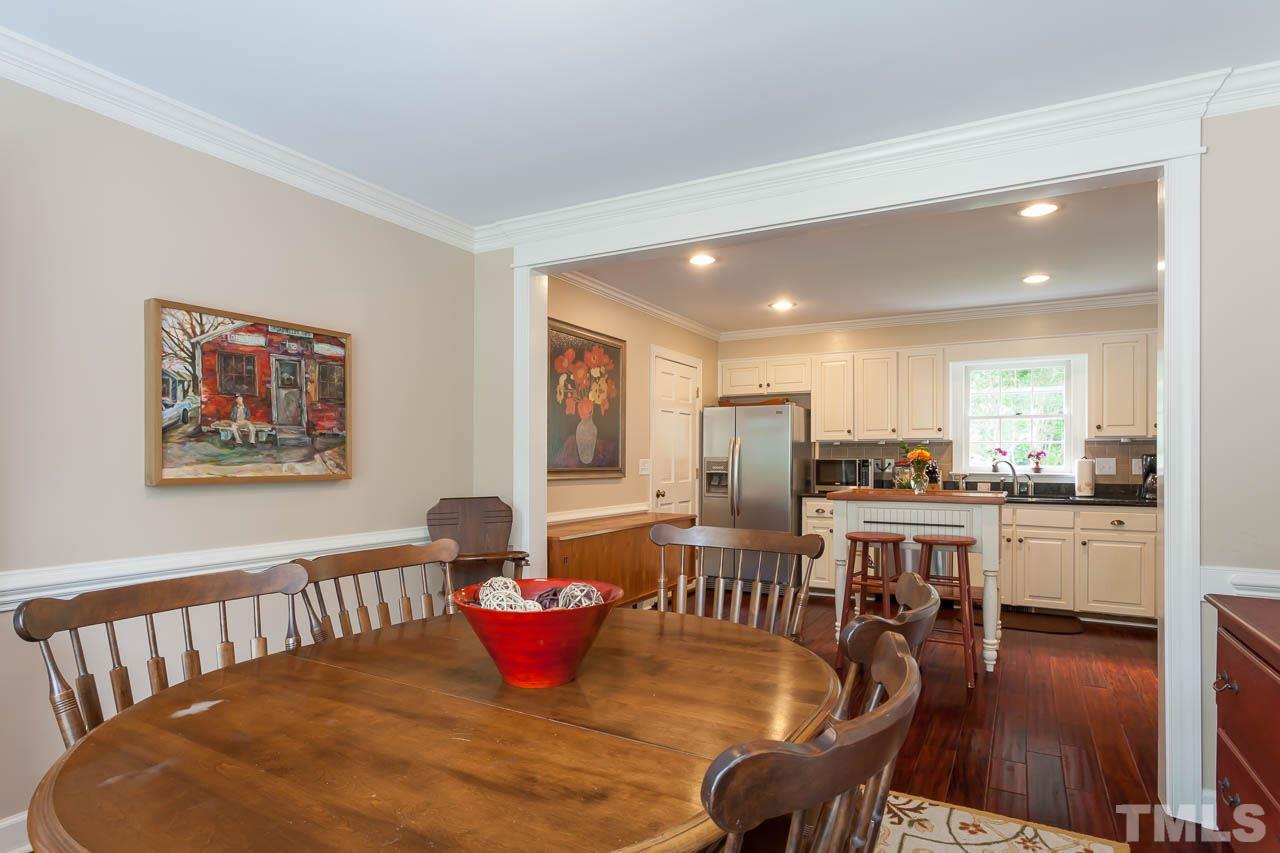 7317 Ridge Grove Court Raleigh, NC 27615 - Photo 5 of 25 a dining room with furniture a window and wooden floor