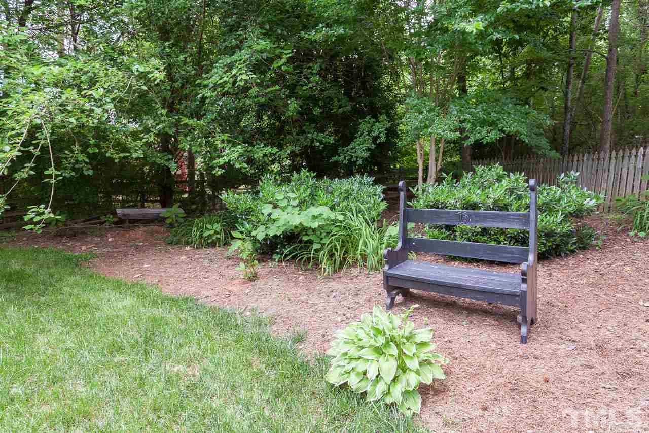 7317 Ridge Grove Court Raleigh, NC 27615 - Photo 10 of 25 a wooden bench sitting in the middle of a yard