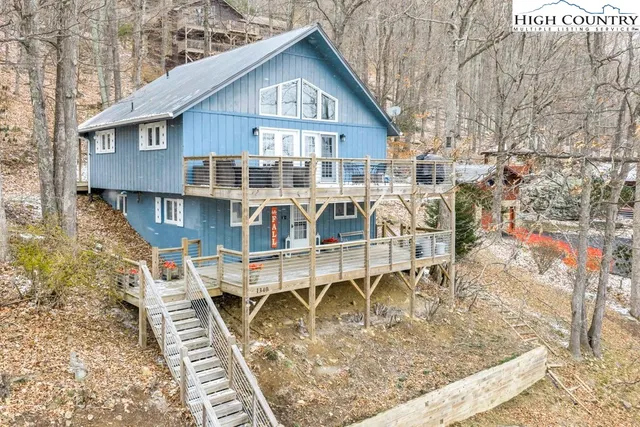 a view of a house with wooden deck and furniture