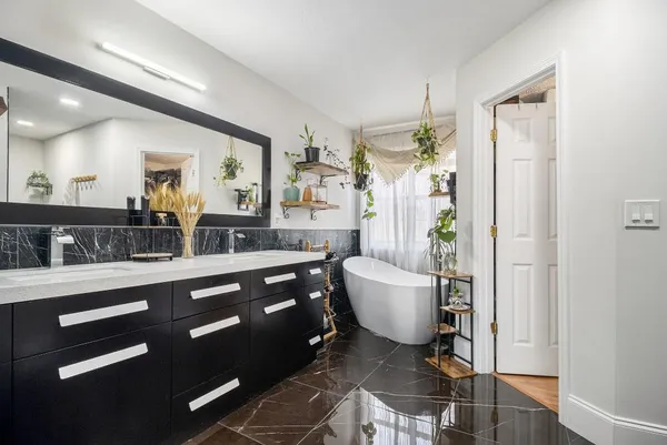 a spacious bathroom with a granite countertop sink a toilet a mirror and shower