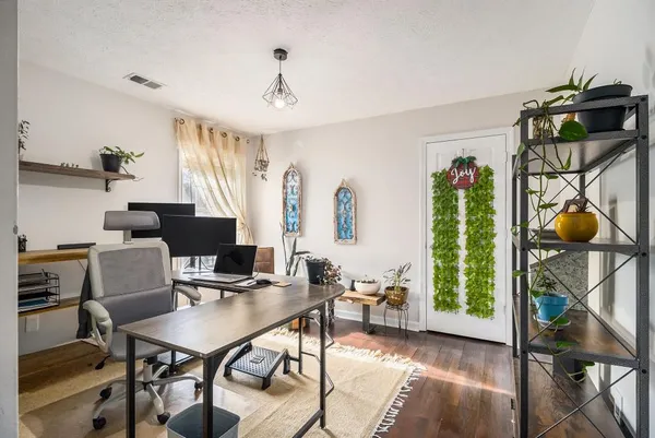 a view of a workspace with furniture and a window