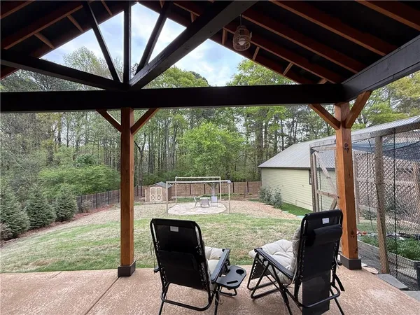 a view of a patio with table and chairs and floor to ceiling window
