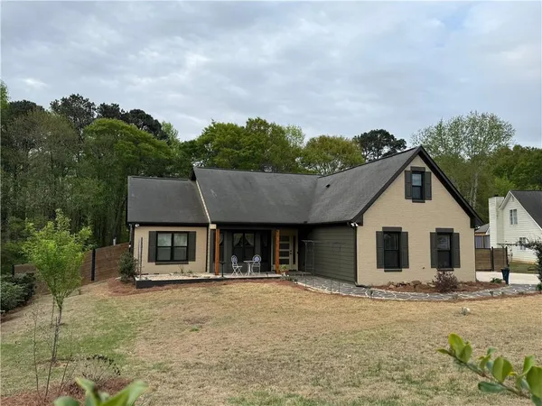 a front view of a house with a garden and yard
