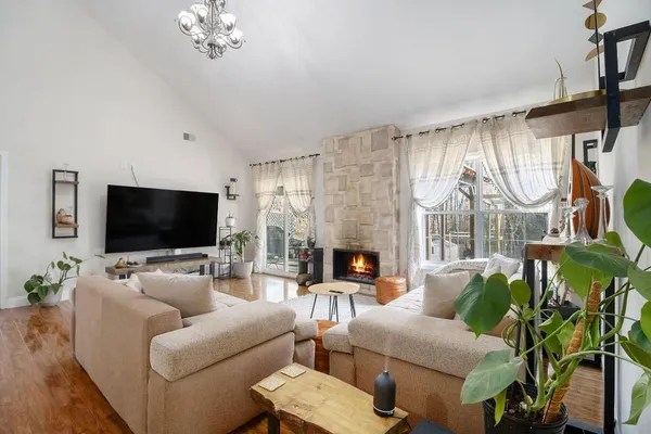 a living room with furniture a flat screen tv and a large window