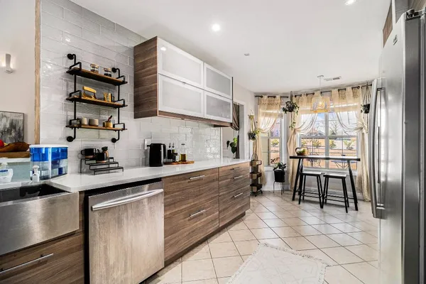 a kitchen with stainless steel appliances granite countertop a refrigerator and a sink