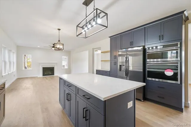 a kitchen with kitchen island a counter top space stainless steel appliances and a chandelier
