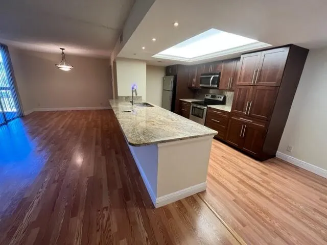 a kitchen with wooden floors and refrigerator