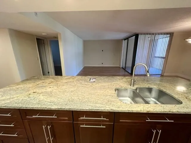 a kitchen with granite countertop a sink and cabinets